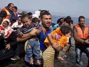 Syrian refugees arrive aboard a dinghy after crossing from Turkey to the island of Lesbos, Greece, Thursday, Sept. 10, 2015. While migrants for years have taken death-defying trips across the Mediterranean to reach the relative peace and comfort of the Europe Union, the flow has hit record proportions this year _ notably with an influx of Syrians, Afghans and Eritreans fleeing trouble back home.(AP Photo/Petros Giannakouris)