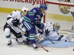 Vancouver Canucks' Bo Horvat, centre, tries to score on San Jose Sharks' Troy Grosenick, right, during first period of NHL pre-season action at the Q Centre in Victoria, B.C., Monday, September 21, 2015. THE CANADIAN PRESS/Chad Hipolito