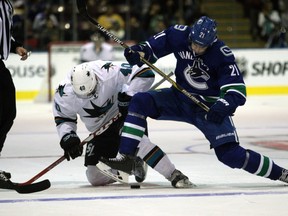 San Jose Sharks' Ryan Carpenter and Vancouver Canucks' Brandon Sutter battle for the puck during last night's preseason opener in North Saanich.