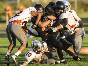 New Westminster’s Rochon Bhattacharya (left) and David Penalver (10) are among the defenders who converged Friday to slow Blaine’s dynamic running back Riley Fritsch during the season opener for both games Friday night across the line. (Steve Bosch, PNG photo)
