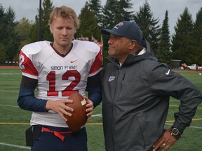 SFU offensive coordinator Joe Paopao shares a light moment with senior quarterback Ryan Stanford after practice earlier this week at the Clan's Terry Fox Field. (Steve Frost, SFU athletics)