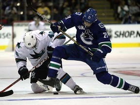 Canucks' Brandon Sutter fights San Jose's Ryan Carpenter for the puck during Monday's preseason opener in North Saanich.