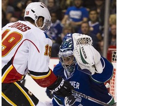 Ryan Miller, here facing David Jones of the Flames on Saturday, didn't skate with the Canucks on Sunday but coach Willie Desjardins said he was merely resting. (Gerry Kahrmann, PNG.)