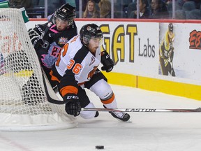 Radel Fazleev of the Calgary Hitmen battles for the puck against Trevor Cox of the Medicine Hat Tigers during a WHL game at Scotiabank Saddledome on October 18, 2014 in Calgary, Alberta, Canada. (Photo by Derek Leung/Getty Images)