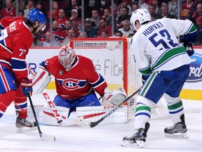 Carey Price of the Montreal Canadiens makes a stick save on the puck in front of teammate Tom Gilbert and Bo Horvat of the Vancouver Canucks during a December 9, 2014 game in Montreal. The Canadiens defeated the Canucks 3-1.   (Photo by Richard Wolowicz/Getty Images)