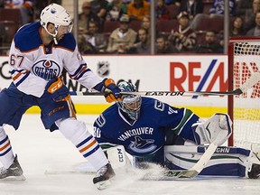 Ryan Miller makes a stop against Edmonton's Benoit Pouliot in the preseason.