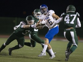 UBC receiver Will Watson is surrounded by Saskatchewan Huskies' Chris Friesen (3) and Dylan Kemp (47) in CIS football action at Griffiths Stadium in Saskatoon, Friday. (GREG PENDER/ STAR-PHOENIX)