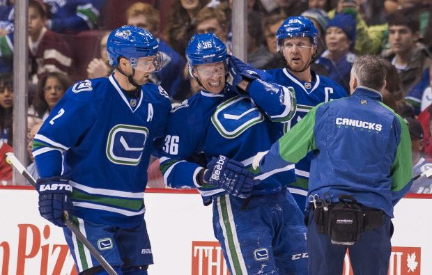 VANCOUVER, BC - NOVEMBER 21: Jannik Hansen #36 of the Vancouver Canucks is helped off the ice by Dan Hamhuis #2 and Henrik Sedin #33 after getting hit by the puck in NHL action against the Chicago Blackhawks on November, 21, 2015 at Rogers Arena in Vancouver, British Columbia, Canada.  (Photo by Rich Lam/Getty Images)