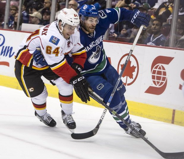 Vancouver Canucks forward Alex Grenier battles the Calgary Flames' Garnet Hathaway in a NHL pre season game at Rogers Arena in Vancouver,  B.C., on September 26, 2015.   (Steve Bosch/PNG )