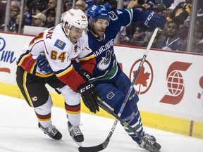 Vancouver Canucks forward Alex Grenier battles the Calgary Flames' Garnet Hathaway in a NHL pre season game at Rogers Arena in Vancouver,  B.C., on September 26, 2015.   (Steve Bosch/PNG )