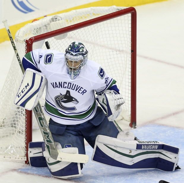 Vancouver Canucks goalie Ryan Miller (30) makes a save with his shoulder during the second period of an NHL hockey game against the New Jersey Devils, Sunday, Nov. 8, 2015, Newark, N.J. The Devils won in overtime 4-3.  (AP Photo/Mel Evans)