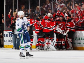 NEWARK, NJ - NOVEMBER 08: The New Jersey Devils celebrate as Chris Higgins #20 of the Vancouver Canucks skates away at the Prudential Center on November 8, 2015 in Newark, New Jersey. The Devils defeated the Canucks in overtime 4-3.  (Photo by Andy Marlin/NHLI via Getty Images)