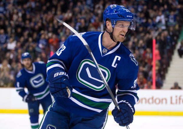 Vancouver Canucks' Henrik Sedin, of Sweden, celebrates after scoring against the Chicago Blackhawks, to make his 900th point, during first period NHL hockey action, in Vancouver, B.C., on Saturday, Nov. 21, 2015. THE CANADIAN PRESS/Darryl Dyck