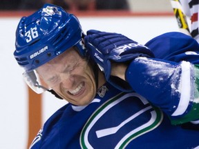 Vancouver Canucks' Jannik Hansen, of Denmark, reacts after being struck in the ear by the puck during first period NHL hockey action against the Chicago Blackhawks, in Vancouver, B.C., on Saturday, Nov. 21, 2015. THE CANADIAN PRESS/Darryl Dyck
