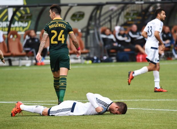 Vancouver Whitecaps forward Octavio Rivero (29) lies on the pitch after missing a shot as Portland Timbers defender Liam Ridgewell (24) walks away during the first half of an MLS western conference semifinal soccer match in Portland, Ore., Sunday, Nov. 1, 2015. (AP Photo/Steve Dykes)