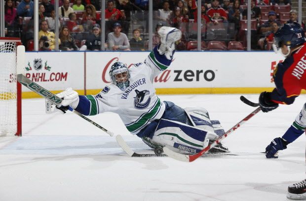 Vancouver Canucks goaltender Ryan Miller, left, stops a shot by Florida Panthers forward Jonathan Huberdeau (11) during the first period of an NHL hockey game, Sunday, Dec. 20, 2015, in Sunrise, Fla. (AP Photo/Joel Auerbach)