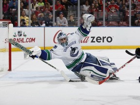 Vancouver Canucks goaltender Ryan Miller, left, stops a shot by Florida Panthers forward Jonathan Huberdeau (11) during the first period of an NHL hockey game, Sunday, Dec. 20, 2015, in Sunrise, Fla. (AP Photo/Joel Auerbach)