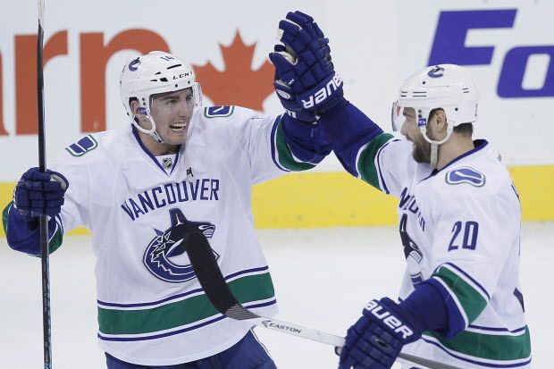 Vancouver Canucks' Chris Higgins (20) and Alexandre Burrows (14) celebrate Higgins' winning shoot out goal over the Winnipeg Jets in NHL action in Winnipeg on Wednesday, March 12, 2014. The Canucks defeated the Jets 3-2. THE CANADIAN PRESS/John Woods ORG XMIT: JGW117