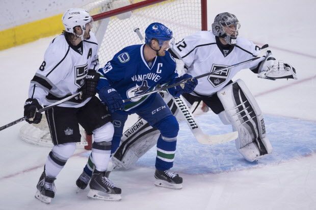 Los Angeles Kings defenceman Drew Doughty (8) tries to clear Vancouver Canucks centre Henrik Sedin (33) from in front of Los Angeles Kings goalie Jonathan Quick (32) during third period NHL action Vancouver, B.C. Monday, Dec. 28, 2015. THE CANADIAN PRESS/Jonathan Hayward