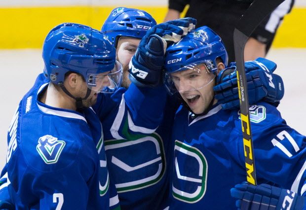 Vancouver Canucks' Dan Hamhuis, from left, Brandon Prust and Radim Vrbata, of the Czech Republic, celebrate Vrbata's third goal against the Buffalo Sabres during the third period of an NHL hockey game in Vancouver, B.C., on Monday December 7, 2015. THE CANADIAN PRESS/Darryl Dyck