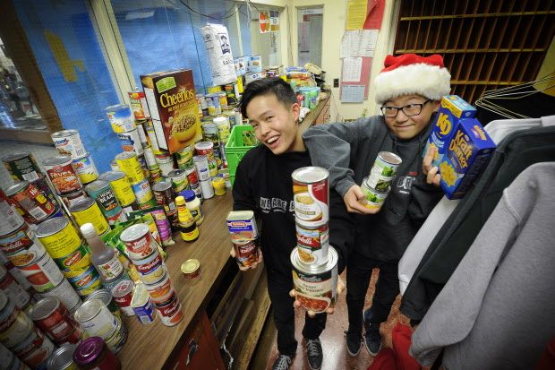 Vancouver B.C. December 16, 2015 Helping others-- Timme Zhao -- (with brother Jimme (r) has collected lots of canned goods for charity here at his Britannia Secondary School in Vancouver on December 16, 2015. Zhao also featured in and around the school where he has worked diligently for the Vancouver Food bank and other charities. Mark van Manen/PNG