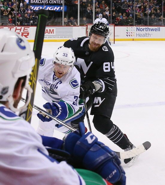 NEW YORK, NY - JANUARY 17: Mikhail Grabovski #84 of the New York Islanders takes a major penalty for boarding against Henrik Sedin #33 of the Vancouver Canucks during the first period at the Barclays Center on January 17, 2016 in the Brooklyn borough of New York City.  (Photo by Bruce Bennett/Getty Images)