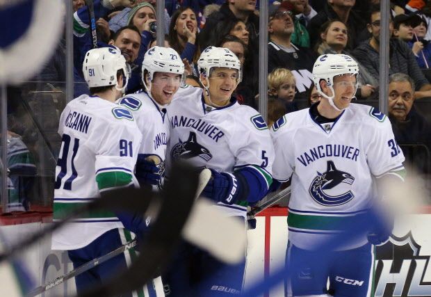 NEW YORK, NY - JANUARY 17: Ben Hutton #27 of the Vancouver Canucks (2nd from left) celebrates his first NHL goal against the New York Islanders at 9:46 of the second period at the Barclays Center on January 17, 2016 in the Brooklyn borough of New York City. Joining him are (l-r) Jared McCann #91, Luca Sbisa #5 and Jannik Hansen #36. (Photo by Bruce Bennett/Getty Images)