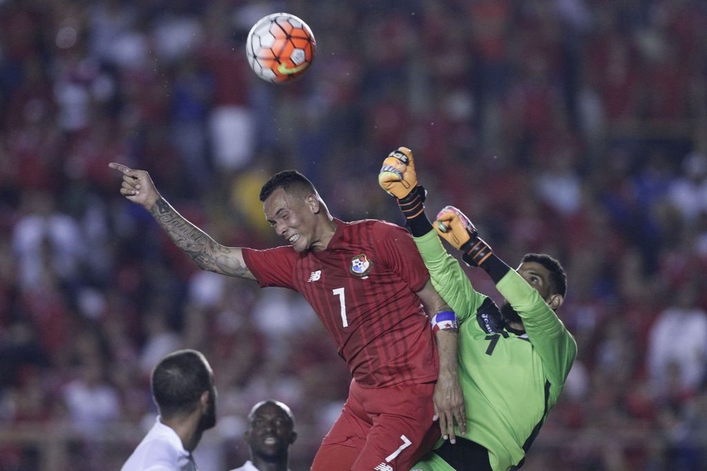CORRECTS FINAL SCORE - Panama's Blas Perez, left, and Cuba's goalkeeper Sandy Sanchez, right, fight for the ball during a qualifying soccer playoff ahead of the Copa America Centenario in Panama City, Friday, Jan. 8, 2016. Panama won the mtach 4-0. (AP Photo/Arnulfo Franco)