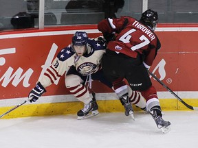 Parker Bowles of the Tri-City Americans is checked by Josh Thrower of the Vancouver Giants during the first period of their WHL game at the Pacific Coliseum on October 16, 2015 in Vancouver, British Columbia, Canada. (Photo by Ben Nelms/Getty Images)