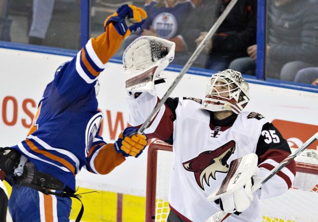 Arizona Coyotes goalie Louis Domingue (35) makes the save as Edmonton Oilers' Jordan Eberle (14) jumps for the puck during third period NHL action in Edmonton, Alta., on Saturday January 2, 2016. THE CANADIAN PRESS/Jason Franson
