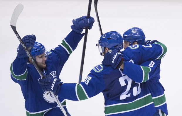 Vancouver Canucks defenseman Chris Tanev (8) right wing Linden Vey (7) and defenseman Alexander Edler (23)celebrates his goal with teammates during third period NHL action Vancouver, B.C. Friday, Jan. 1, 2016. THE CANADIAN PRESS/Jonathan Hayward