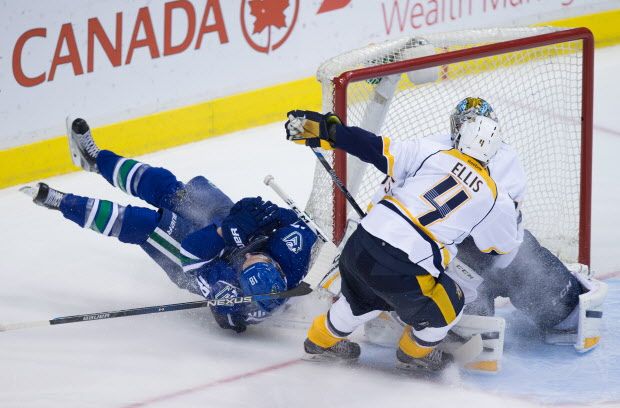 Vancouver Canucks' Jake Virtanen, left, crashes into the net after a scoring chance on Nashville Predators' goalie Pekka Rinne, back right, of Finland, as Ryan Ellis (4) defends during third period NHL hockey action, in Vancouver on Tuesday, Jan. 26, 2016. THE CANADIAN PRESS/Darryl Dyck
