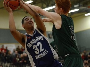 Jelani Morris (left) of Surrey’s Tamanawis Wildcats, grabs a rebound ahead of Daniel Stead of Langley’s Walnut Grove Gators during Friday action at the Legal Beagle Invitational in PoCo. Morris and the Wildcats are amongst the 24-team senior varsity field at this week’s 25th annual Surrey RCMP Classic. (PNG photo — Howard Tsumura)