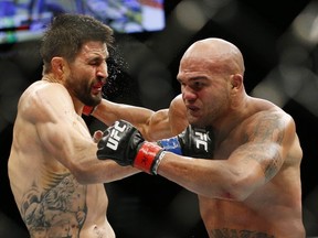 Robbie Lawler, right, hits Carlos Condit during a welterweight championship mixed martial arts bout at UFC 195, Saturday, Jan. 2, 2016, in Las Vegas. (AP Photo/John Locher)