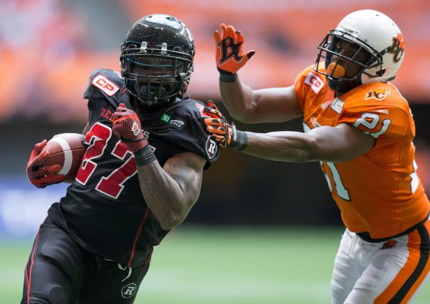 Ottawa Redblacks' Jeremiah Johnson, left, runs past B.C. Lions' Ryan Phillips to score a touchdown during the second half of a CFL football game in Vancouver, B.C., on Sunday, September 13, 2015. Mike Reilly, Johnson and Adarius Bowman were named CFL top performers of the week on Tuesday. THE CANADIAN PRESS/Darryl Dyck