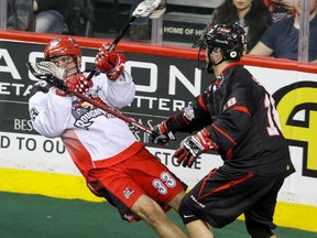 Vancouver Stealth sniper Logan Schuss takes down Calgary Roughnecks defender Jon Harnett in a Jan. 30 game in Calgary. Schuss had been a force with the Stealth this season. (Calgary Sun photo.)