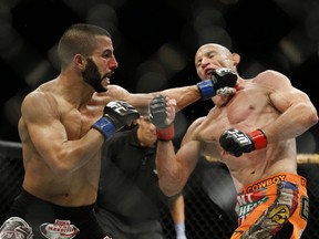 John Makdessi punches Donald Cerrone during their lightweight mixed martial arts bout at UFC 187 on Saturday, May 23, 2015, in Las Vegas. (AP Photo/John Locher)