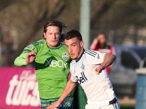 Whitecaps Russell Teibert fights off Seattle's Erik Friberg in the first half of Wednesday's pre-season friendly in Tucson, Ariz.