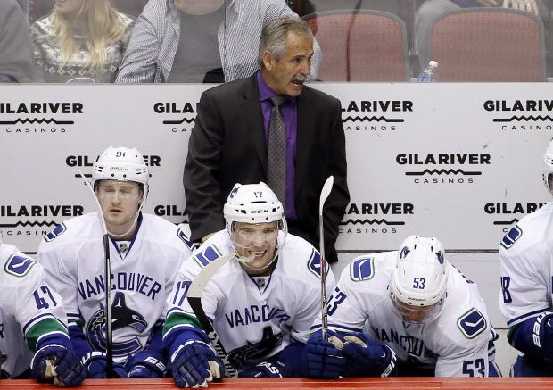 Vancouver Canucks coach Willie Desjardins, top, shouts instructions to his players as he stands behind Jared McCann (91), Radim Vrbata (17), of the Czech Republic, and Bo Horvat (53) during the second period of the Coyotes' NHL hockey game against the Arizona Coyotes on Wednesday, Feb. 10, 2016, in Glendale, Ariz. (AP Photo/Ross D. Franklin)