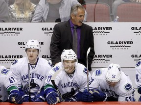 Vancouver Canucks coach Willie Desjardins, top, shouts instructions to his players as he stands behind Jared McCann (91), Radim Vrbata (17), of the Czech Republic, and Bo Horvat (53) during the second period of the Coyotes' NHL hockey game against the Arizona Coyotes on Wednesday, Feb. 10, 2016, in Glendale, Ariz. (AP Photo/Ross D. Franklin)