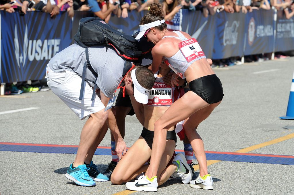 LOS ANGELES, CA - FEBRUARY 13: Steve Edwards (L) and Amy Cragg (R) help Shalene Flanagan to her feet after the U.S. Olympic Team Trials Womens Marathon on February 13, 2016 in Los Angeles, California. (Photo by Joshua Blanchard/Getty Images)