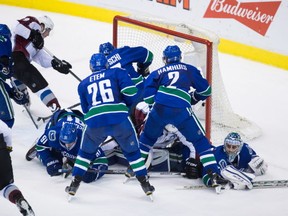 Vancouver Canucks' goalie Ryan Miller, bottom right, lies on the ice after Colorado Avalanche's Jarome Iginla, bottom, second left, fell on him as Matt Duchene, top left, scores during the third period of an NHL hockey game in Vancouver, B.C., on Sunday February 21, 2016. THE CANADIAN PRESS/Darryl Dyck