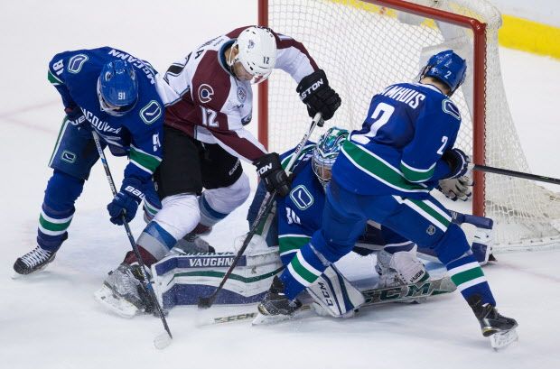 Vancouver Canucks' goalie Ryan Miller, third left, stops Colorado Avalanche's Jarome Iginla (12) as Jared McCann, left, and Dan Hamhuis, right, defend during the third period of an NHL hockey game in Vancouver, B.C., on Sunday February 21, 2016. THE CANADIAN PRESS/Darryl Dyck