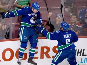 Vancouver Canucks' Hunter Shinkaruk, left, celebrates his goal during a pre-season NHL game in Vancouver, on September 16, 2013. The Calgary Flames acquired Shinkaruk from the Vancouver Canucks for centre Markus Granlund on Monday. THE CANADIAN PRESS/Darryl Dyck