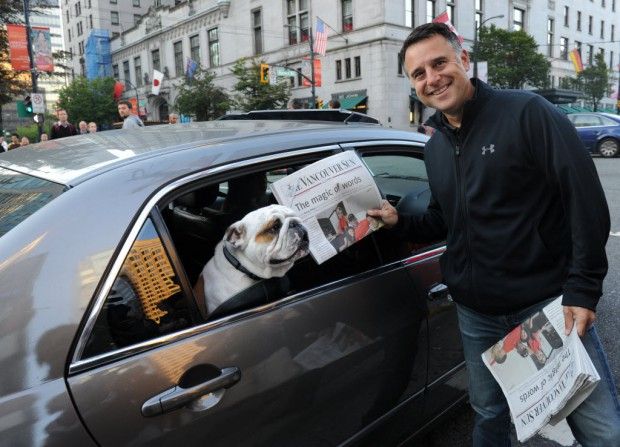 Laurence Gilman hands newspaper to dog. Contrary to Province reports, he is no longer a Canucks AGM.
