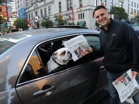 Laurence Gilman hands newspaper to dog. Contrary to Province reports, he is no longer a Canucks AGM.