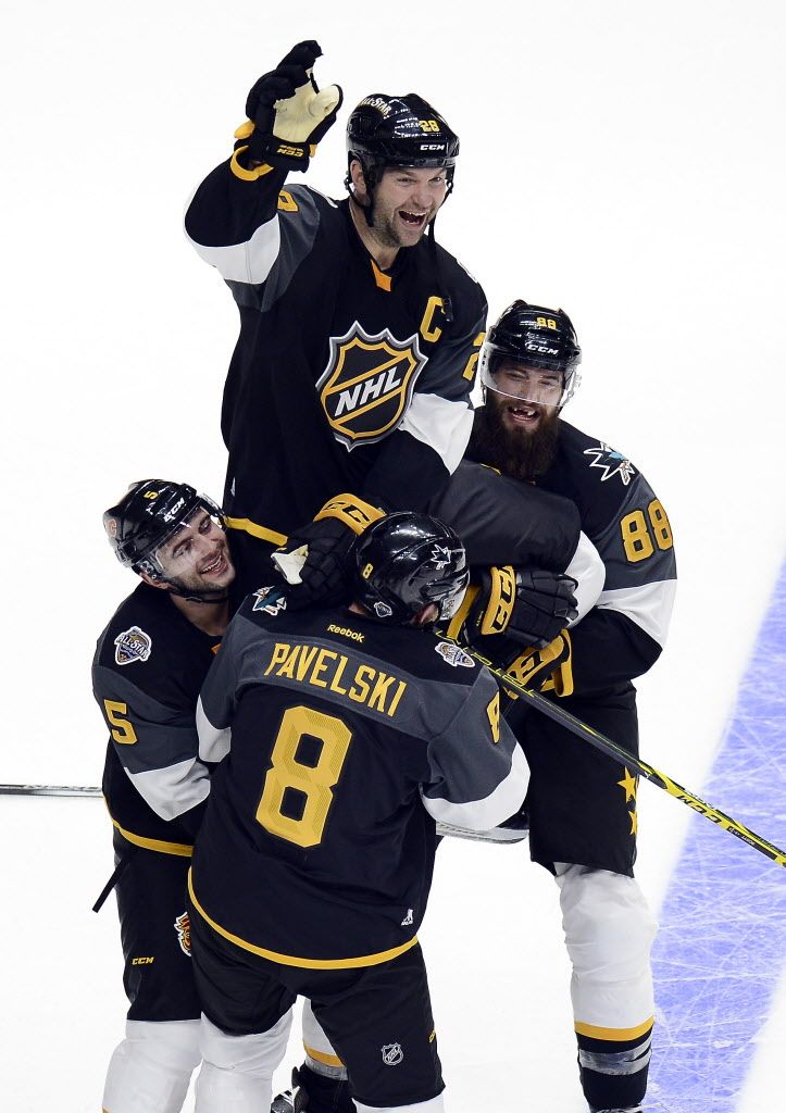 Pacific Division forward John Scott (28) is lifted up by teammates Mark Giordano (5), of the Calgary Flames, Joe Pavelski (8), and Brent Burns (88), of the San Jose Sharks after they defeated the Atlantic Division team 1-0 at an NHL hockey All-Star championship game, Sunday, Jan. 31, 2016, in Nashville, Tenn. The Pacific Division won 1-0. (AP Photo/Mark Zaleski)