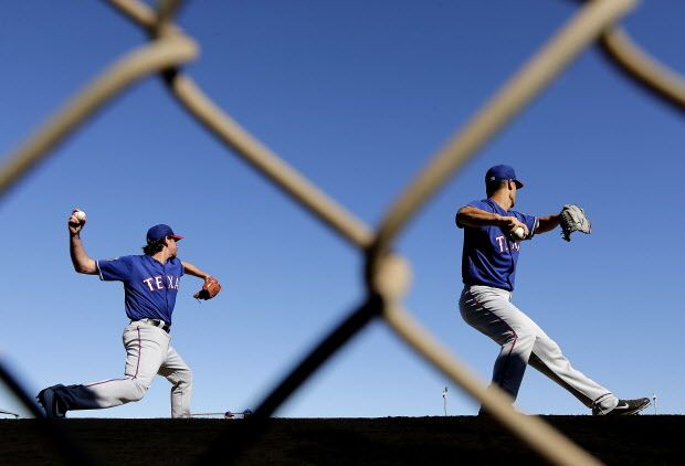 Texas Rangers pitchers Nick Tepesch, left, and Jeremy Guthrie throw during spring training baseball practice Sunday, Feb. 21, 2016, in Surprise, Ariz. (AP Photo/Charlie Riedel)