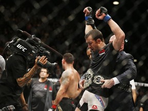 Luke Rockhold, right, reacts after defeating Chris Weidman, left, in a middleweight  championship mixed martial arts bout at UFC 194, Saturday, Dec. 12, 2015, in Las Vegas. (AP Photo/John Locher)
