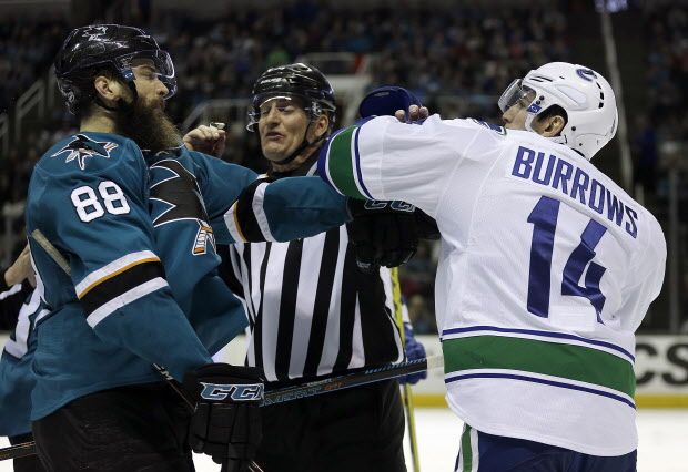 An official separates Vancouver Canucks' Alex Burrows, right, from San Jose Sharks' Brent Burns (88) during the third period of an NHL hockey game Saturday, March 5, 2016, in San Jose, Calif. Vancouver won 4-2. (AP Photo/Ben Margot)